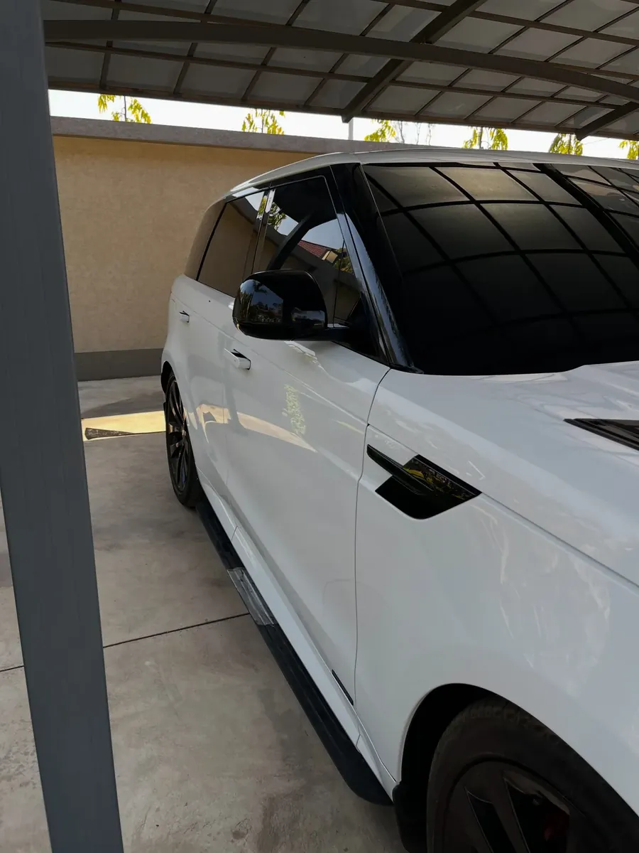 Range Rover Sport, side view under a carport, all glass tinted